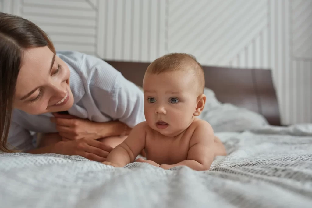 Baby happily lifting their head during tummy time on a soft mat, supporting neck strength, motor development, and healthy movement patterns.