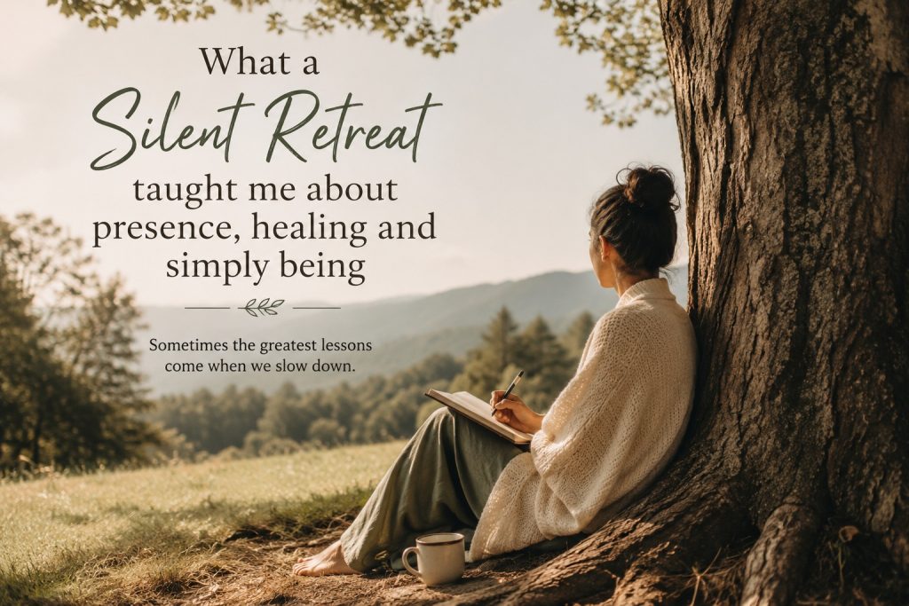 A woman sits peacefully beneath a large tree in nature, journaling and reflecting during a silent retreat as warm sunlight filters through the landscape, symbolising stillness, healing and personal growth.